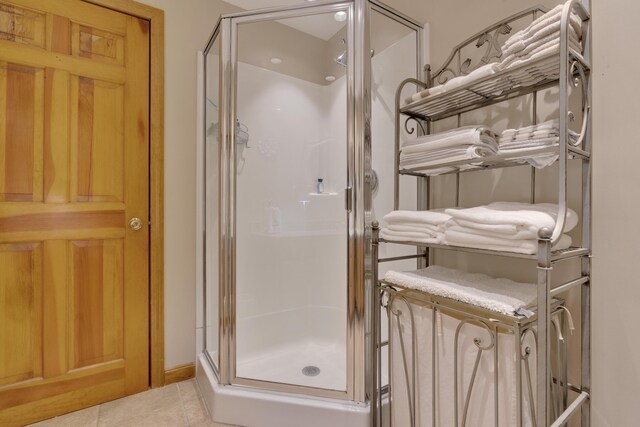 full bath with tile patterned flooring and a shower stall