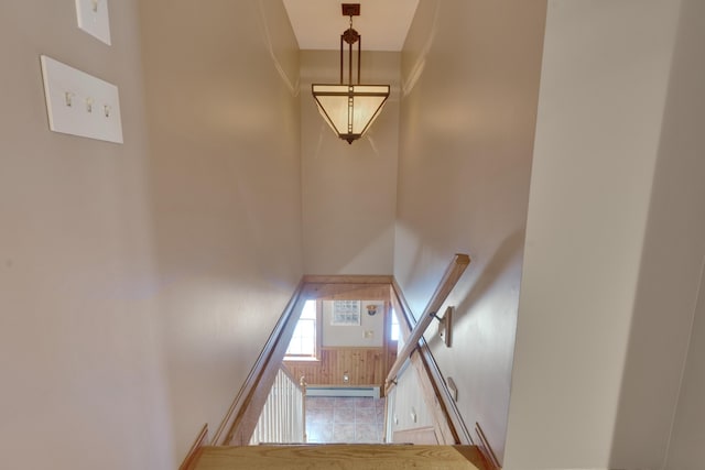 stairs featuring a baseboard heating unit and a towering ceiling