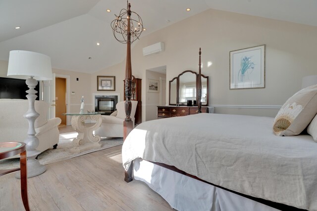 bedroom featuring a multi sided fireplace, recessed lighting, wood finished floors, high vaulted ceiling, and a wall mounted AC