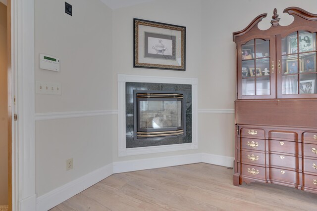 unfurnished living room featuring baseboards and light wood finished floors