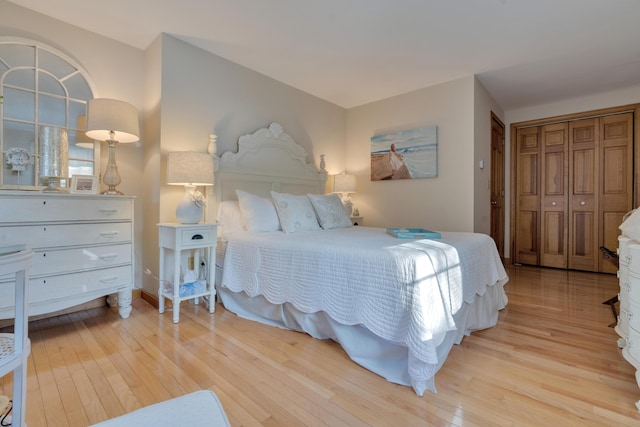 bedroom featuring light wood finished floors and baseboards