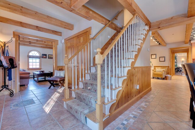 stairs featuring tile patterned flooring and beam ceiling