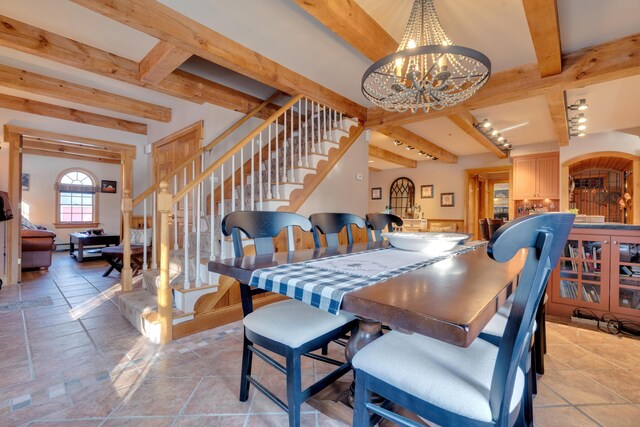 dining area featuring beam ceiling, stairway, and an inviting chandelier