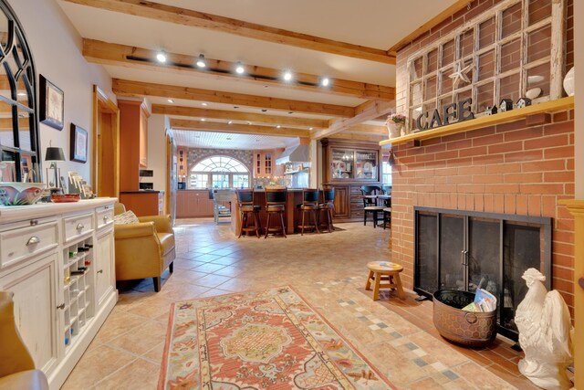 living room featuring light tile patterned floors, beam ceiling, indoor bar, and a fireplace