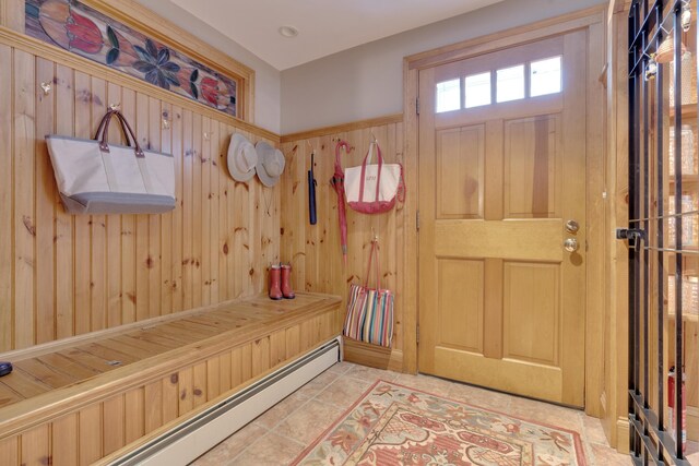 mudroom featuring tile patterned floors and wood walls