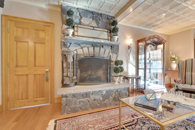 living area with ornamental molding, an ornate ceiling, a fireplace, and wood finished floors