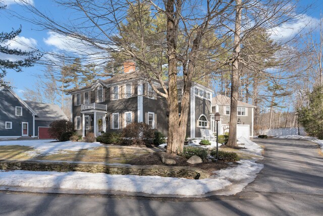 view of front of home with aphalt driveway, a balcony, and an attached garage