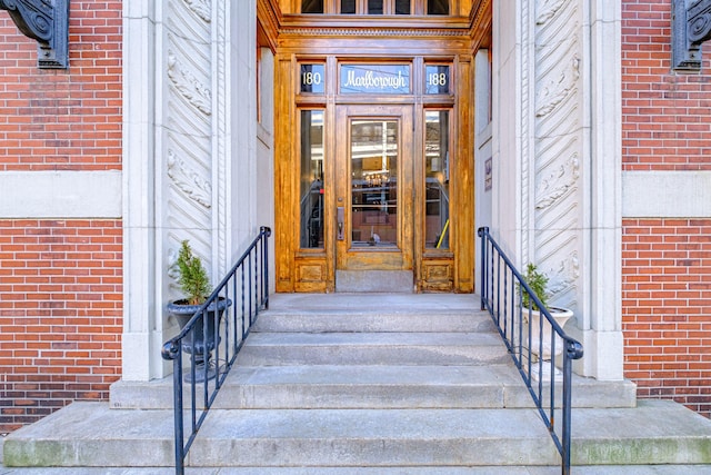 entrance to property featuring brick siding