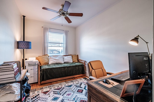 bedroom featuring a ceiling fan, light wood finished floors, and ornamental molding