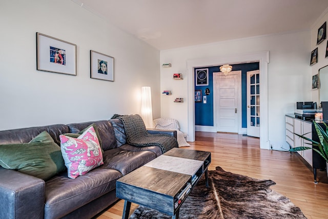 living room with light wood-style floors, baseboards, and ornamental molding