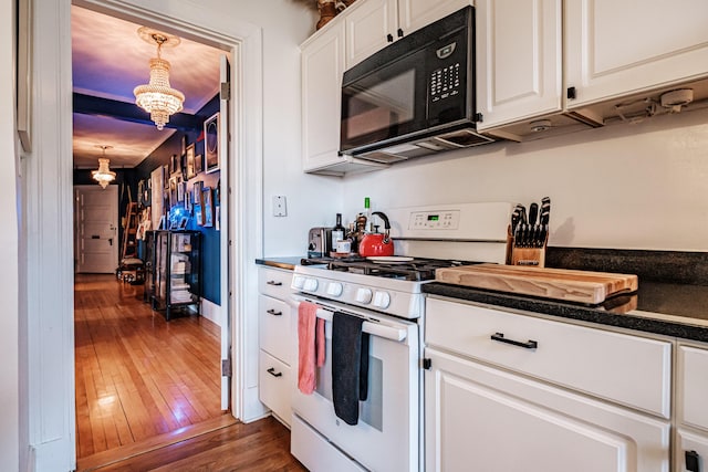 kitchen with dark countertops, dark wood-style floors, white cabinetry, black microwave, and white range with gas stovetop