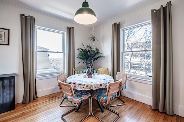 dining area with a wealth of natural light, baseboards, and light wood-style flooring