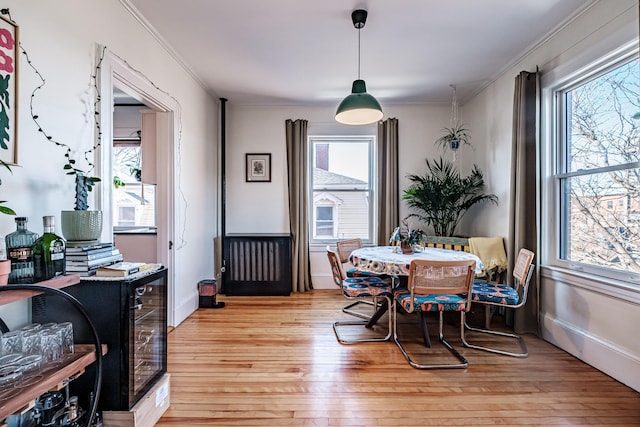 dining room with light wood-type flooring and ornamental molding