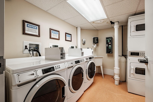 common laundry area with washer and dryer, baseboards, light colored carpet, and stacked washing maching and dryer