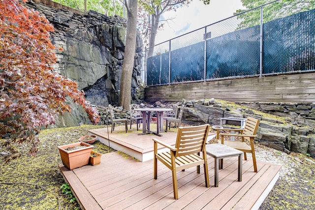 deck with outdoor dining area and fence