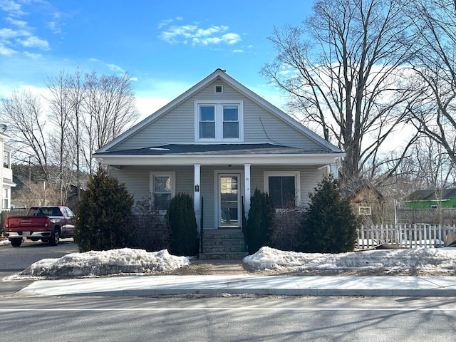 bungalow-style home with a porch and fence