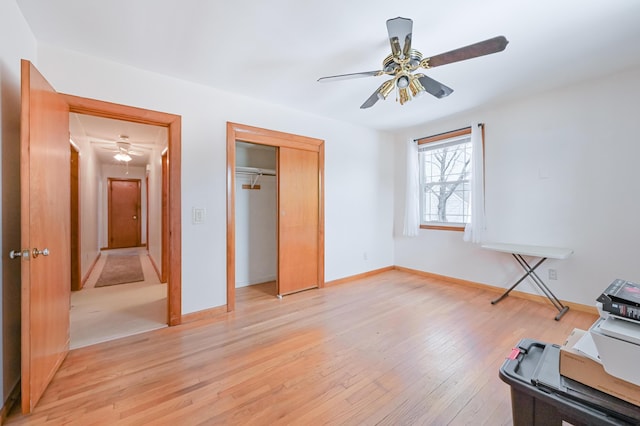 unfurnished bedroom with light wood-type flooring, baseboards, a closet, and ceiling fan