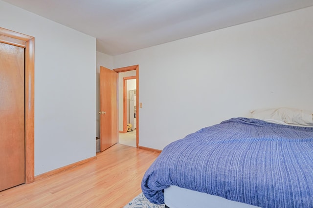 bedroom featuring light wood finished floors and baseboards