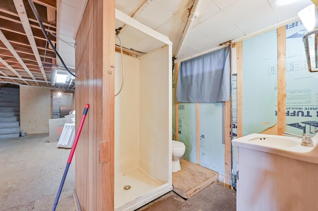 full bathroom featuring vanity, toilet, unfinished concrete flooring, and a shower stall