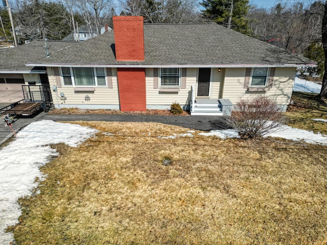 single story home with entry steps, a front lawn, roof with shingles, and a chimney