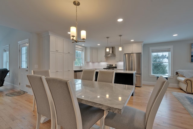 dining area featuring recessed lighting, baseboards, a notable chandelier, and light wood finished floors