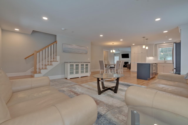 living room featuring recessed lighting, stairs, and light wood-style floors