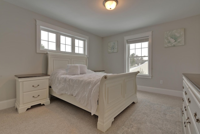 bedroom with baseboards and light colored carpet