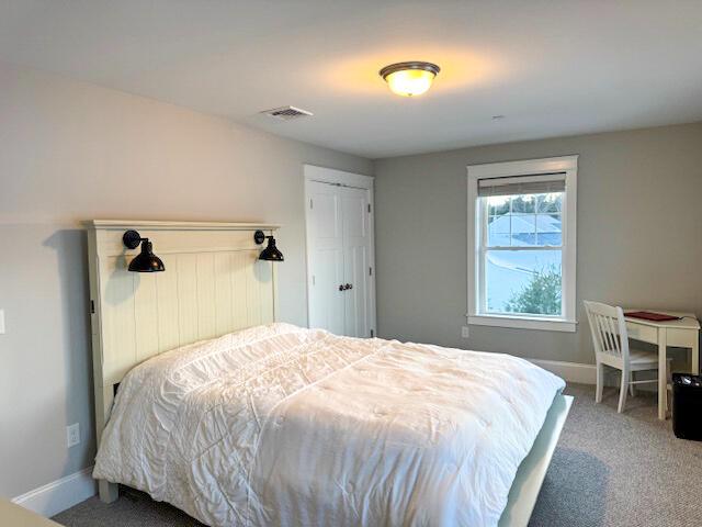 bedroom with visible vents, carpet floors, and baseboards