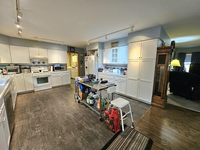 kitchen with glass insert cabinets, decorative backsplash, appliances with stainless steel finishes, dark wood-style floors, and white cabinetry