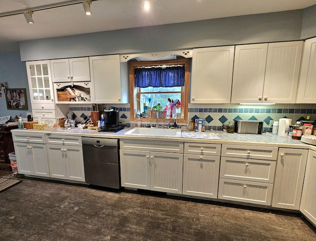 kitchen featuring a sink, decorative backsplash, dishwasher, and light countertops