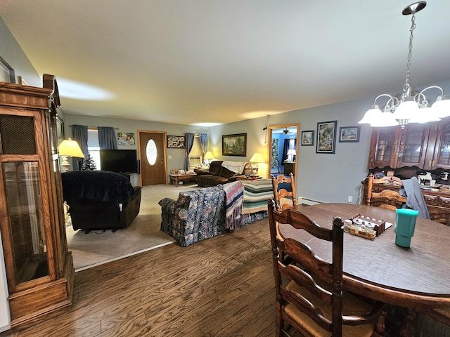 dining room featuring a chandelier, a baseboard radiator, and wood finished floors