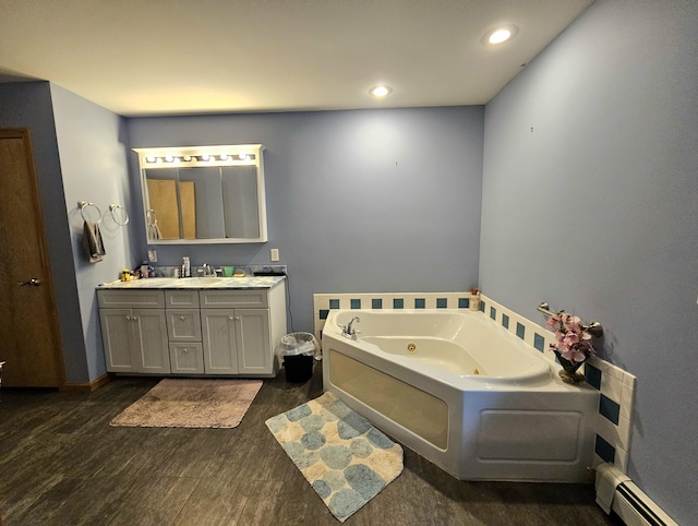 bathroom featuring vanity, wood finished floors, recessed lighting, a whirlpool tub, and baseboard heating