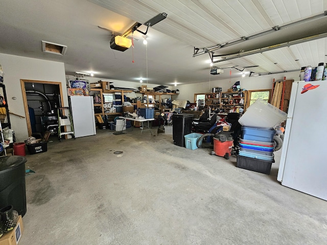 garage featuring a garage door opener and freestanding refrigerator