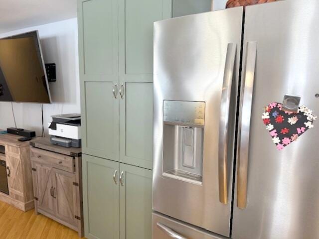 kitchen with green cabinetry, light wood-type flooring, and stainless steel fridge with ice dispenser