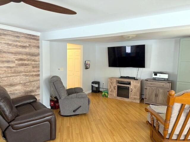 living area featuring light wood-type flooring and ceiling fan