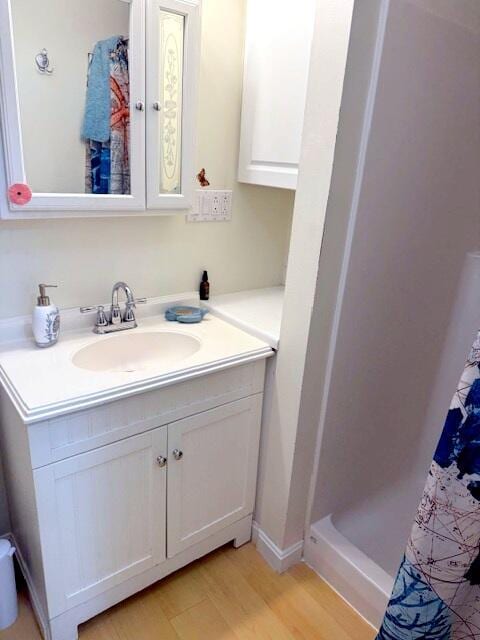 bathroom featuring a stall shower, vanity, and wood finished floors