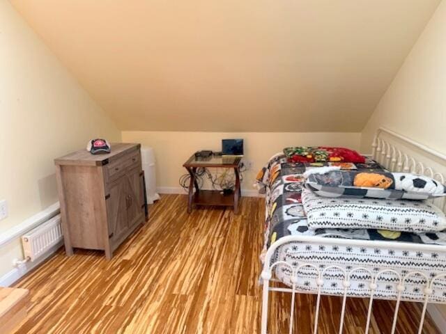 bedroom with vaulted ceiling, baseboards, visible vents, and light wood-type flooring