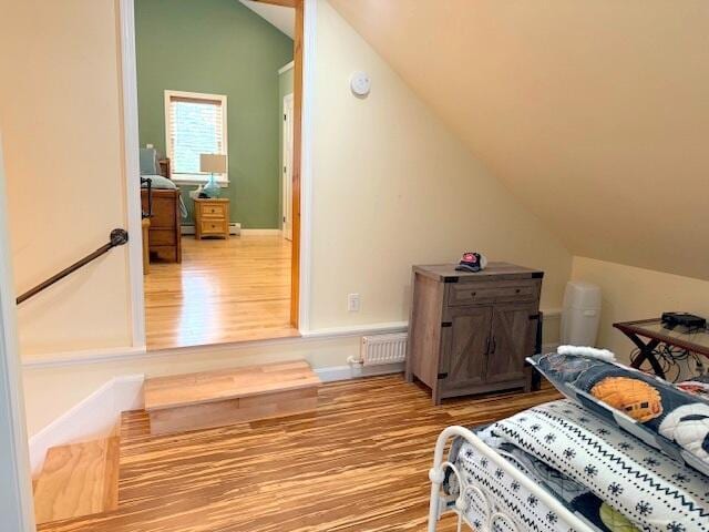 bedroom with wood finished floors and vaulted ceiling