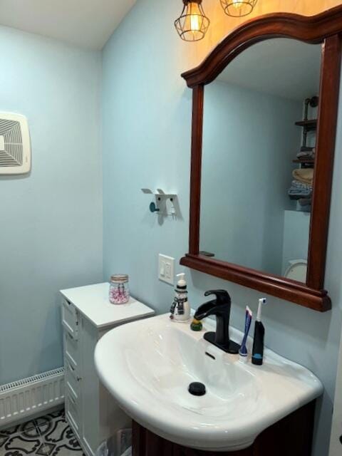 bathroom featuring tile patterned flooring, a wall unit AC, and a sink