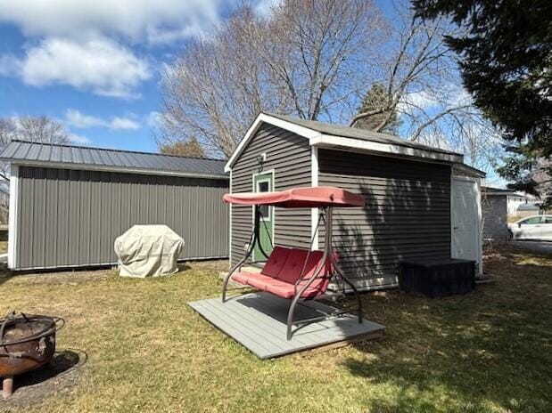 view of outdoor structure featuring a fire pit and an outbuilding