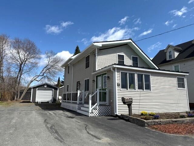 traditional home with driveway, an outbuilding, and a garage