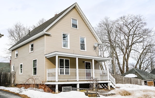 view of front facade featuring covered porch and fence