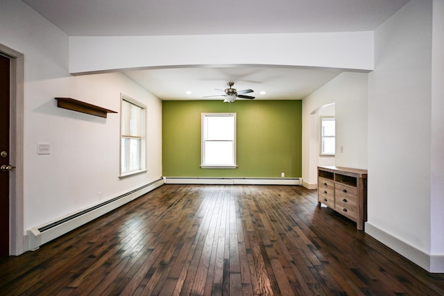 unfurnished room featuring baseboard heating, baseboards, dark wood-type flooring, and a ceiling fan