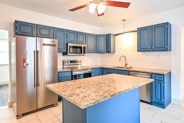 kitchen featuring tasteful backsplash, blue cabinetry, light stone counters, stainless steel appliances, and a sink