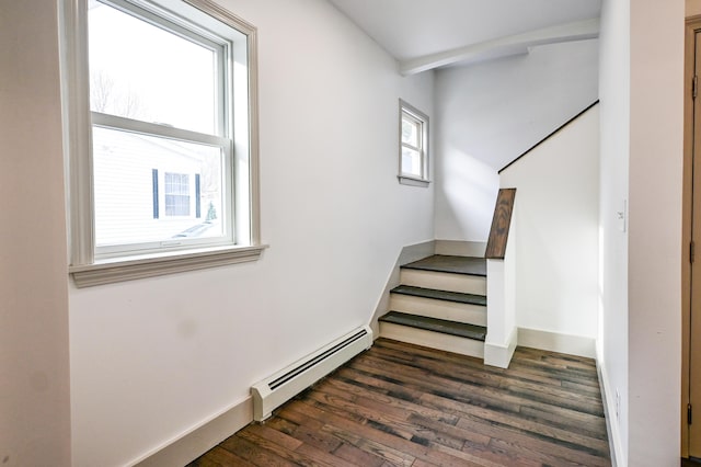 stairway featuring baseboard heating, baseboards, and wood finished floors