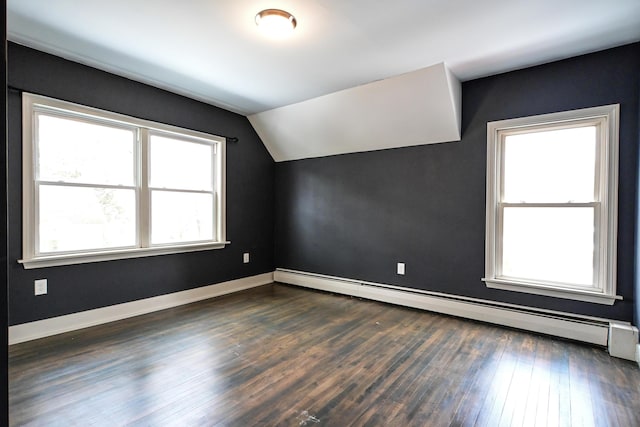 additional living space featuring baseboards, dark wood-type flooring, lofted ceiling, and a baseboard radiator