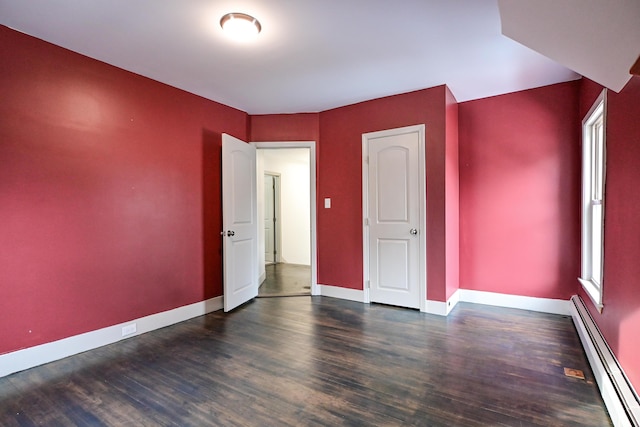 unfurnished room featuring wood finished floors, baseboards, and baseboard heating