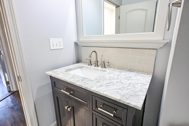 bathroom featuring decorative backsplash, wood finished floors, and vanity