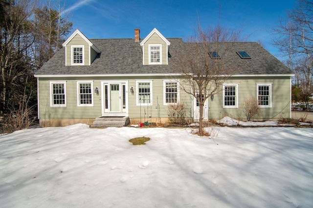 new england style home with a chimney and a shingled roof