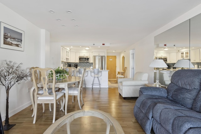 living room with recessed lighting, baseboards, and wood finished floors